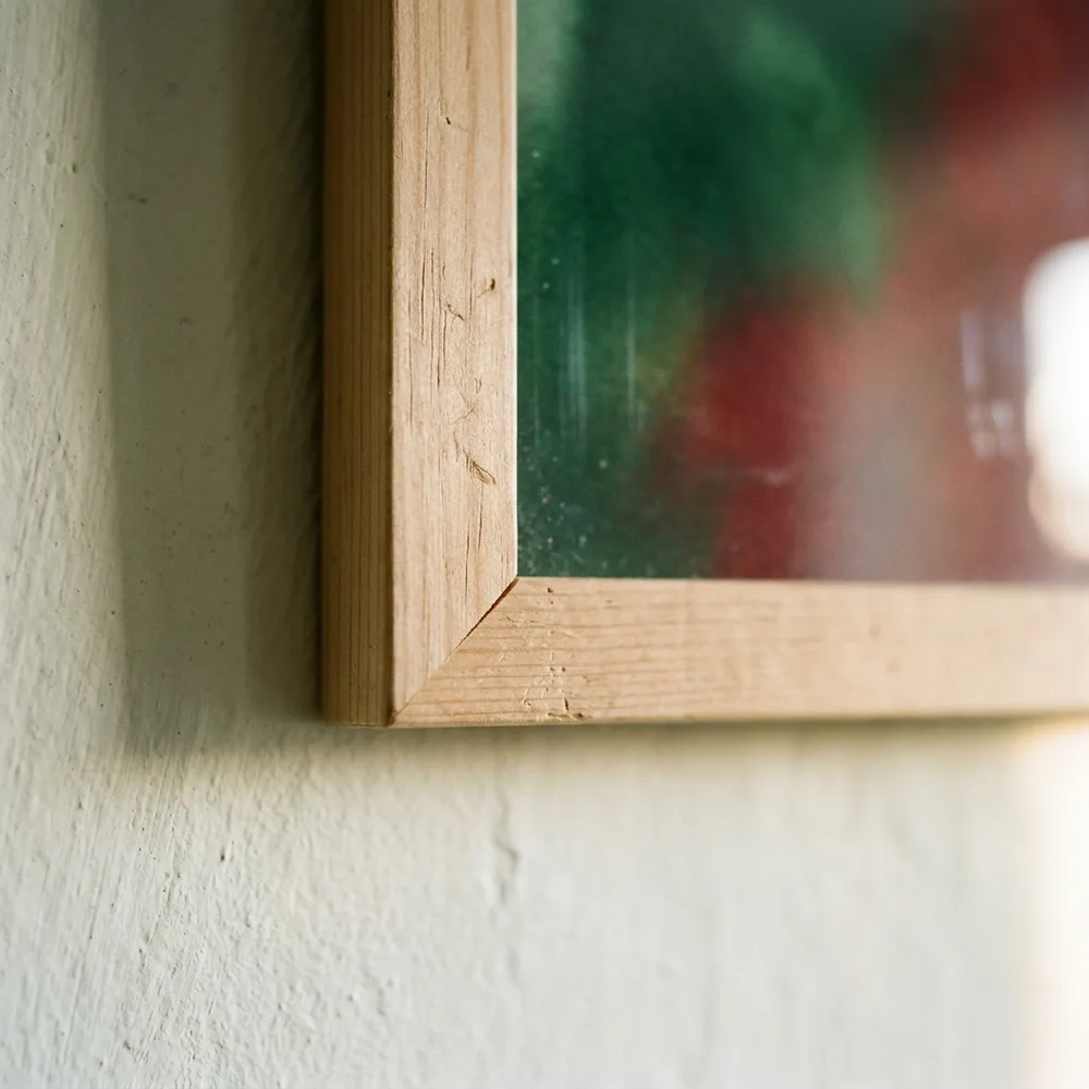 The corner of a natural wood frame, the sheet full to the timber